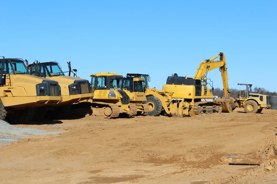 Chantier de terrassement en extérieur avec pelleteuse compacte jaune sur chenilles en fonctionnement